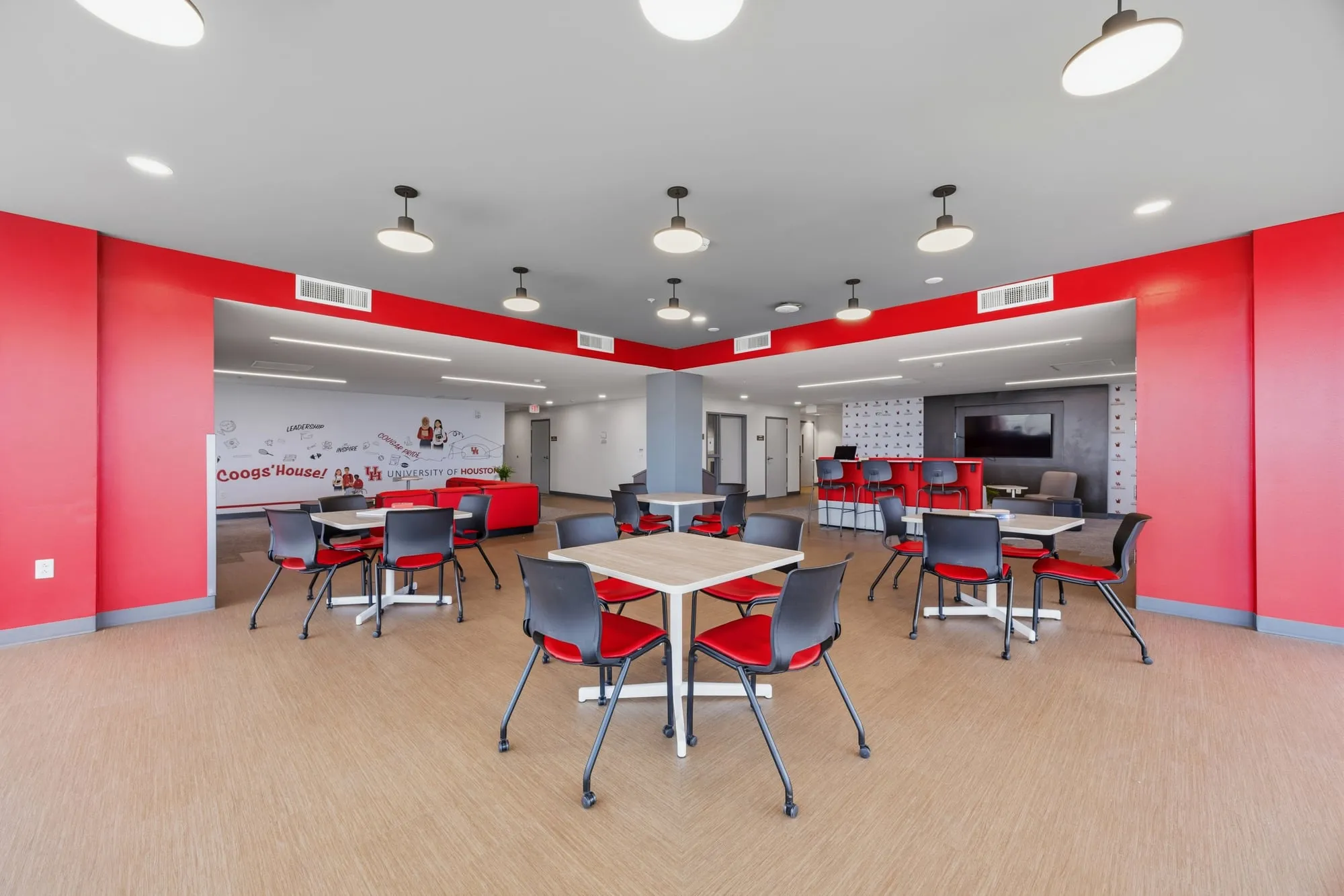 Community dining room with red walls at the University of Houston student housing
