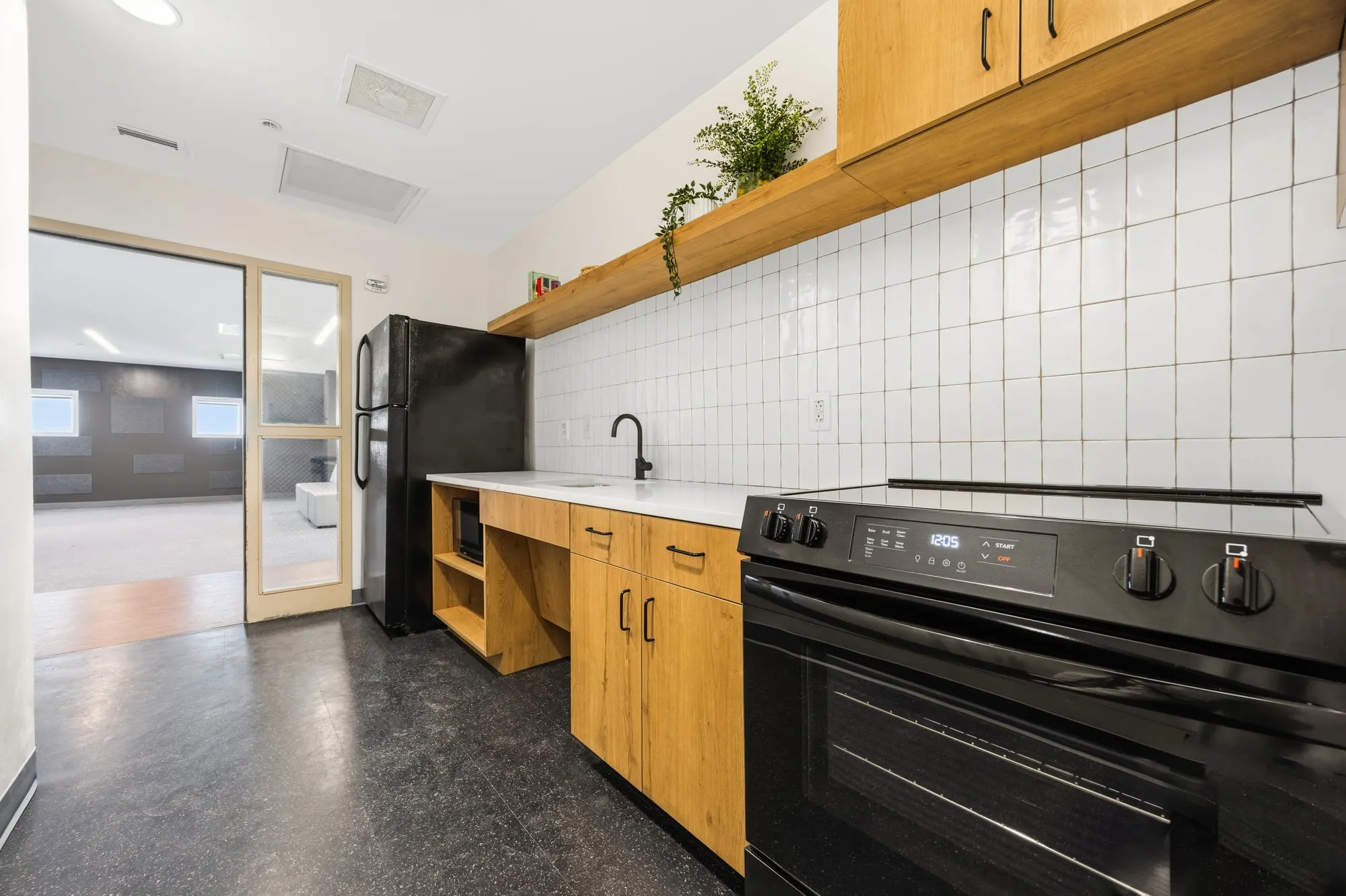 Shared kitchen with wood cabinetry at the University of Houston student housing